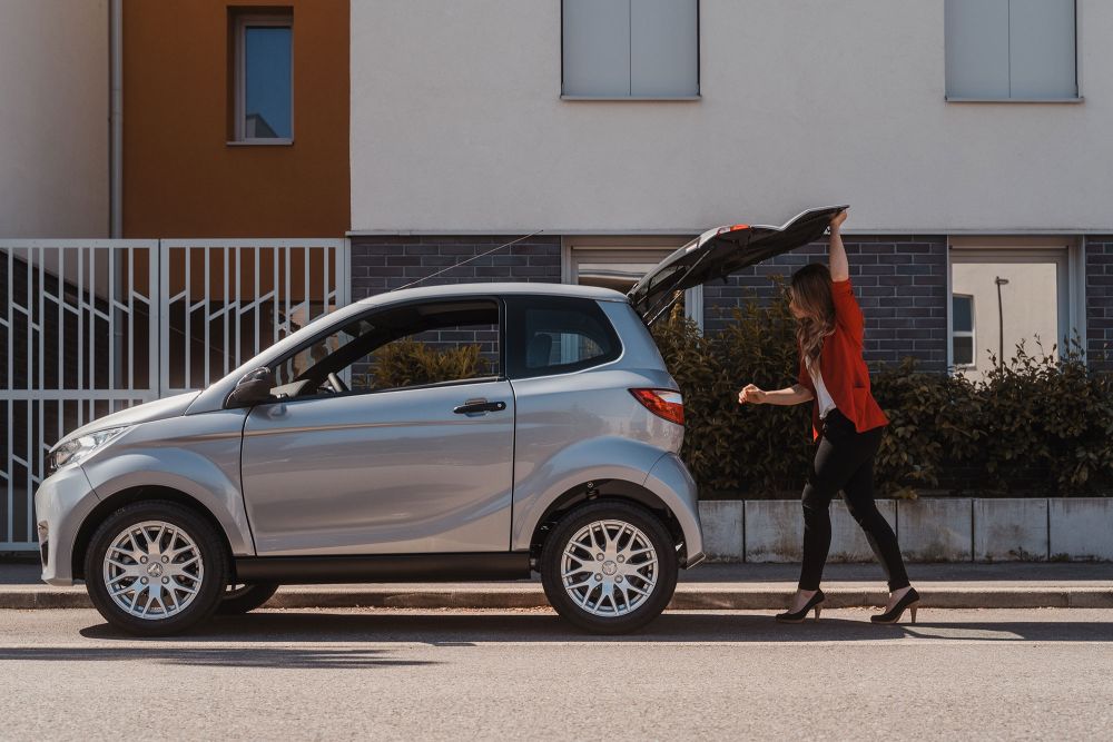 Mujer mirando el maletero de su coche sin carnet aparcado