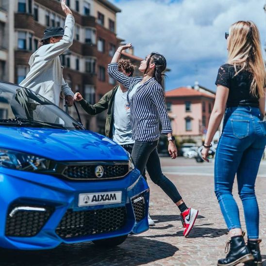 Adolescentes celebrando junto a un Coche sin carnet AIXAM